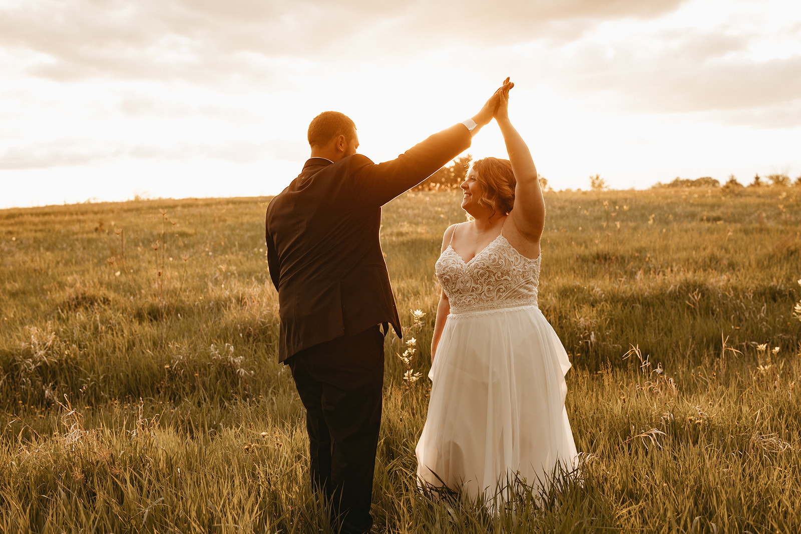 bride and groom dancing during sunset golden hour photos